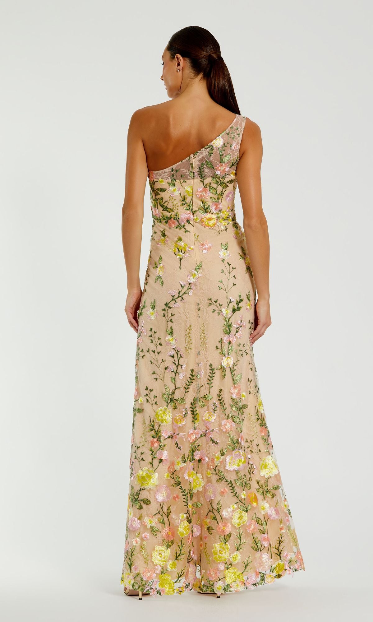 A woman wearing the Mac Duggal 68606 yellow floral-print formal dress stands facing away from the camera.